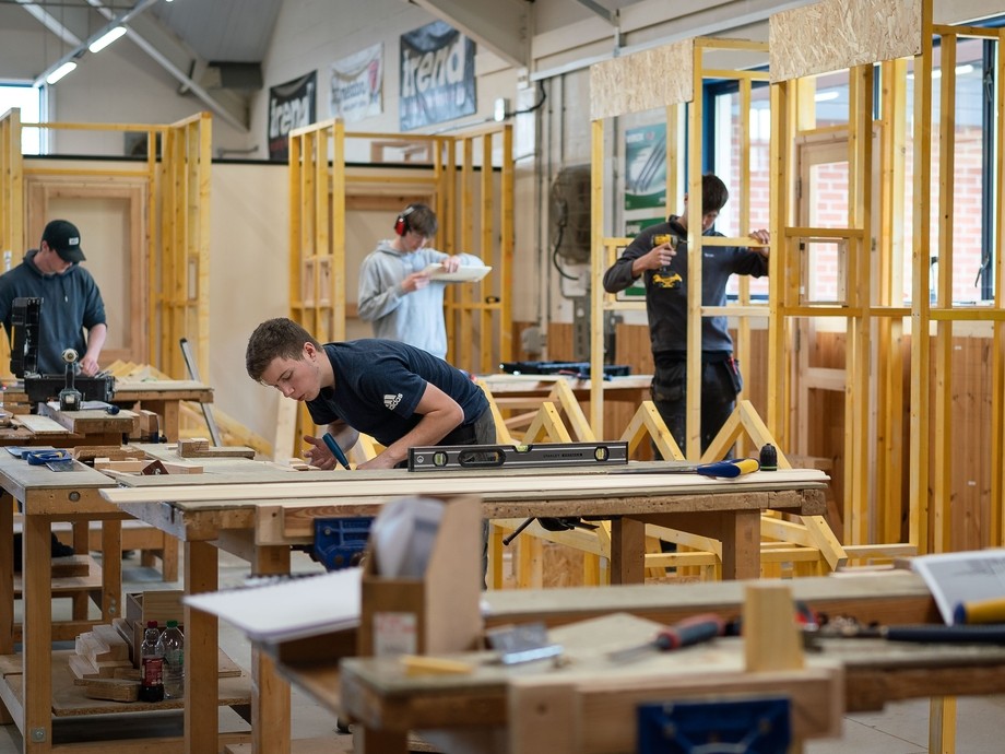 a group of students practicing site carpentry in a workshop