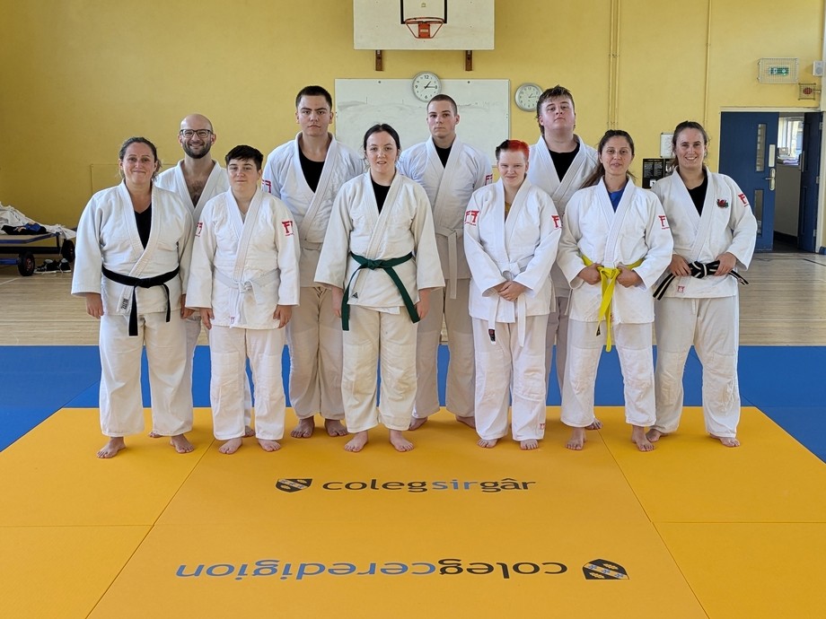 A group of participants in the gym wearing white judo outfits