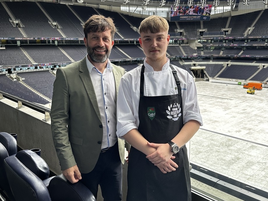 Oliver standing in the stadium with his lecturer
