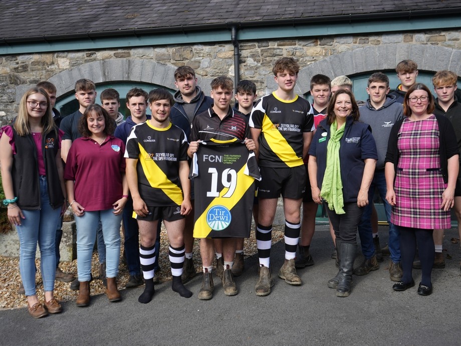 A group outside including students, charity reps and rugby squad