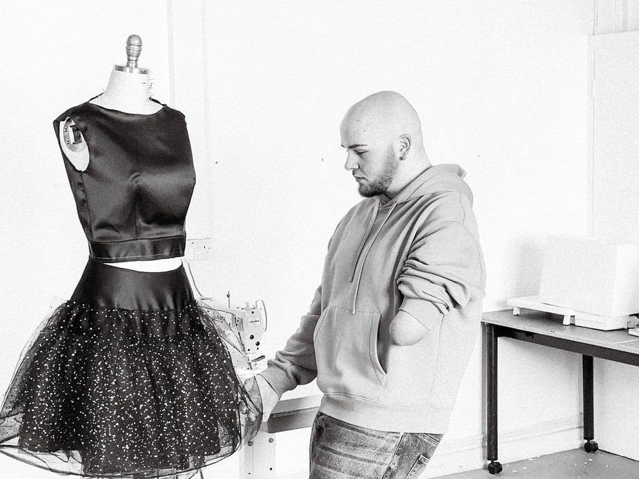 Ryan Rix adjusting dress on mannequin 