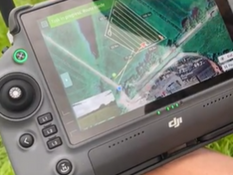 The remote control of the drone with grass as a background