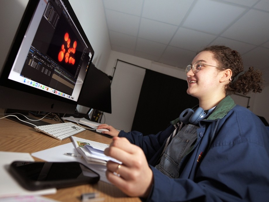 Student sitting at a computer creating a 3D animation