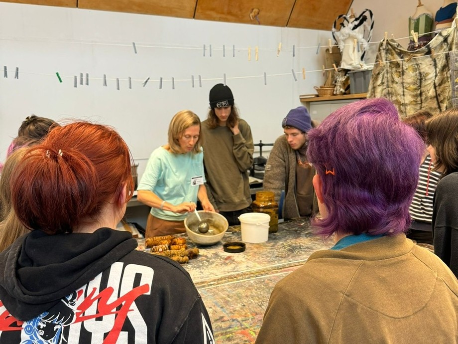 A team of people standing around a table, actively participating in a discussion and exchanging thoughts