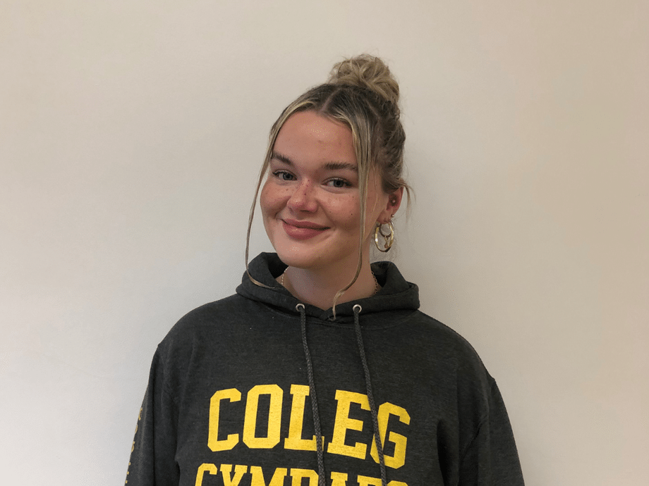 A student with a Coleg Cymraeg hoodie on in yellow and grey