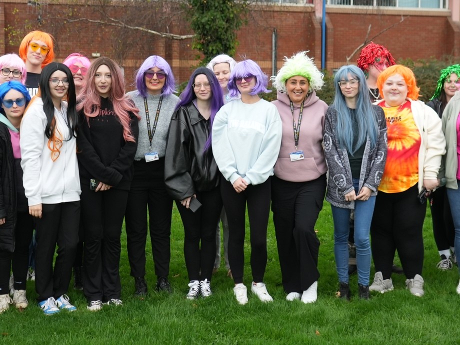 learners stood in a group wearing colourful wigs for a charity walk