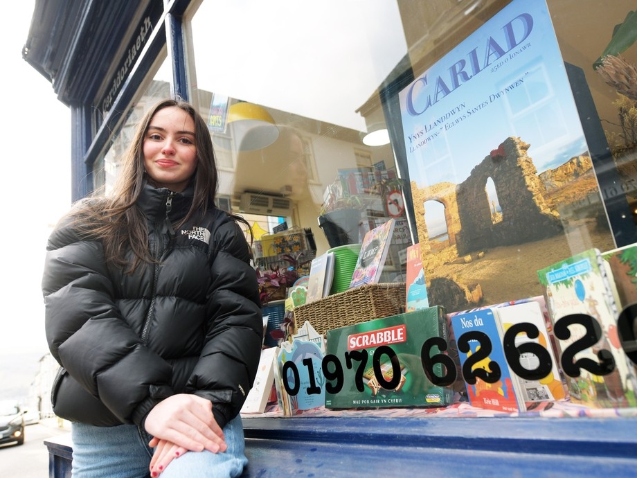 Student outside a shop window in Aberystwyth town 