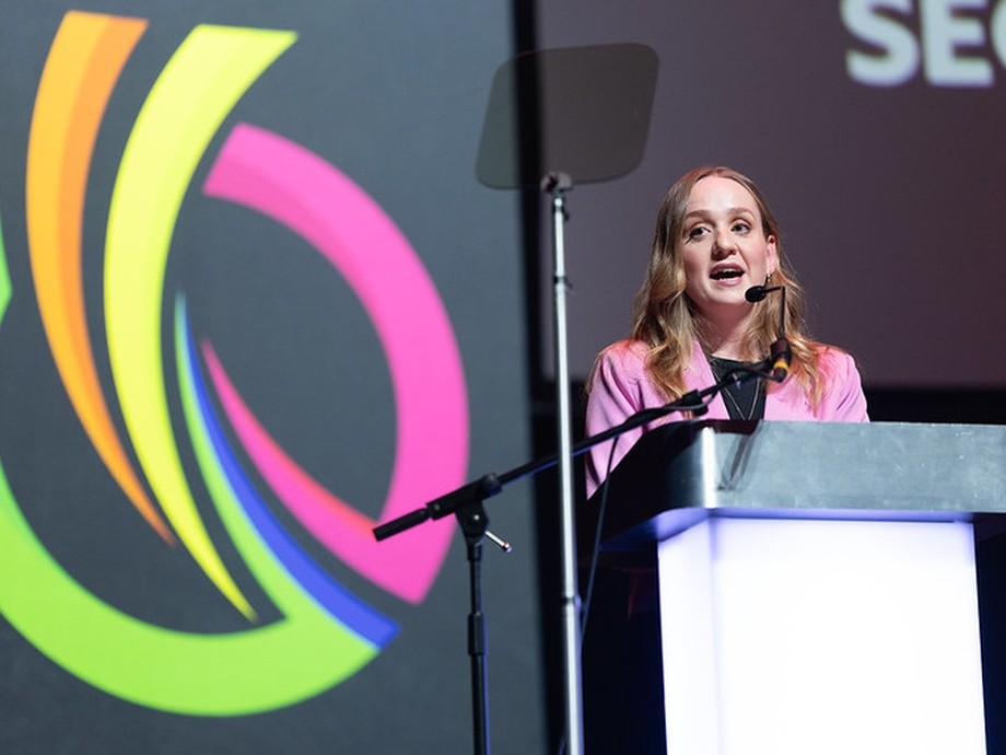 the presenter on stage talking in the Wales final
