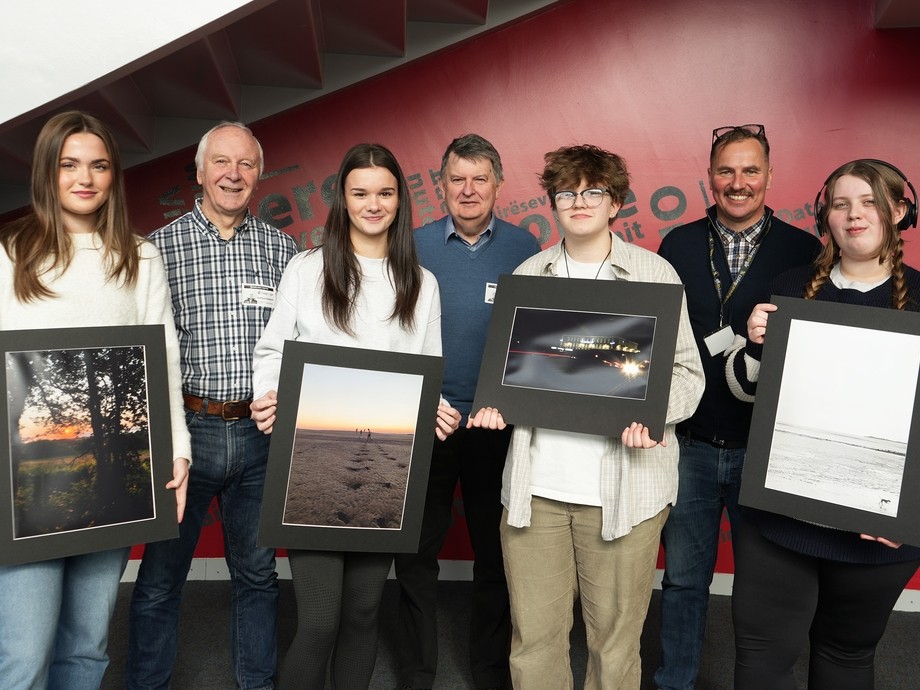 Winning students holding up their artwork with lecturer Simon and two people from the photo society