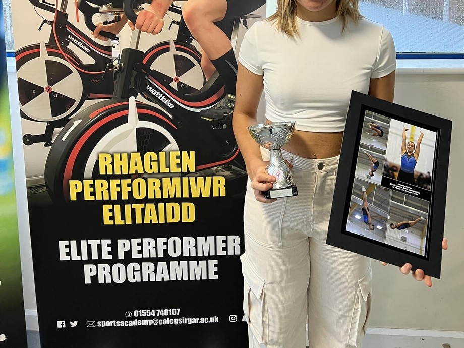 Maddie standing by the Elite Performer Programme Stand