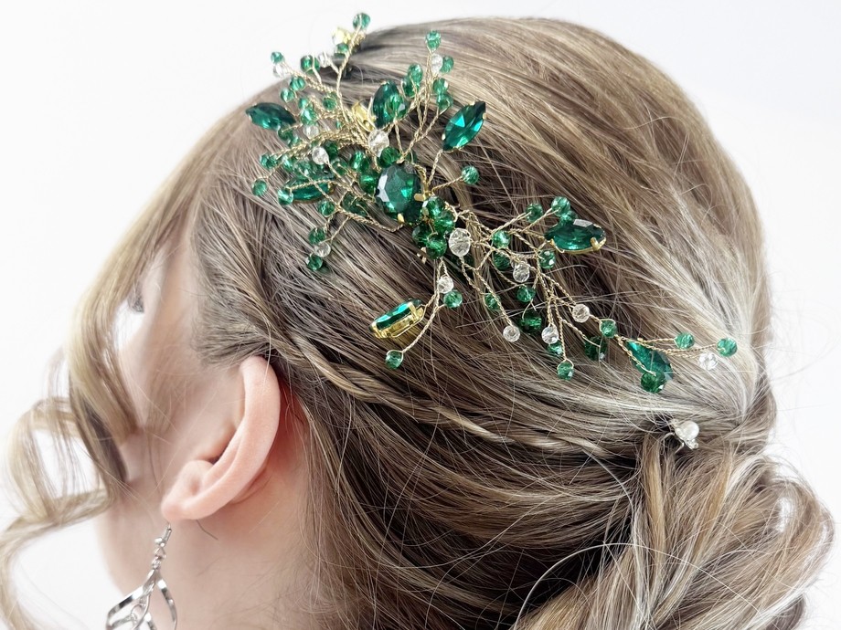 a model's hair showing hair up with a green sparkly accessory