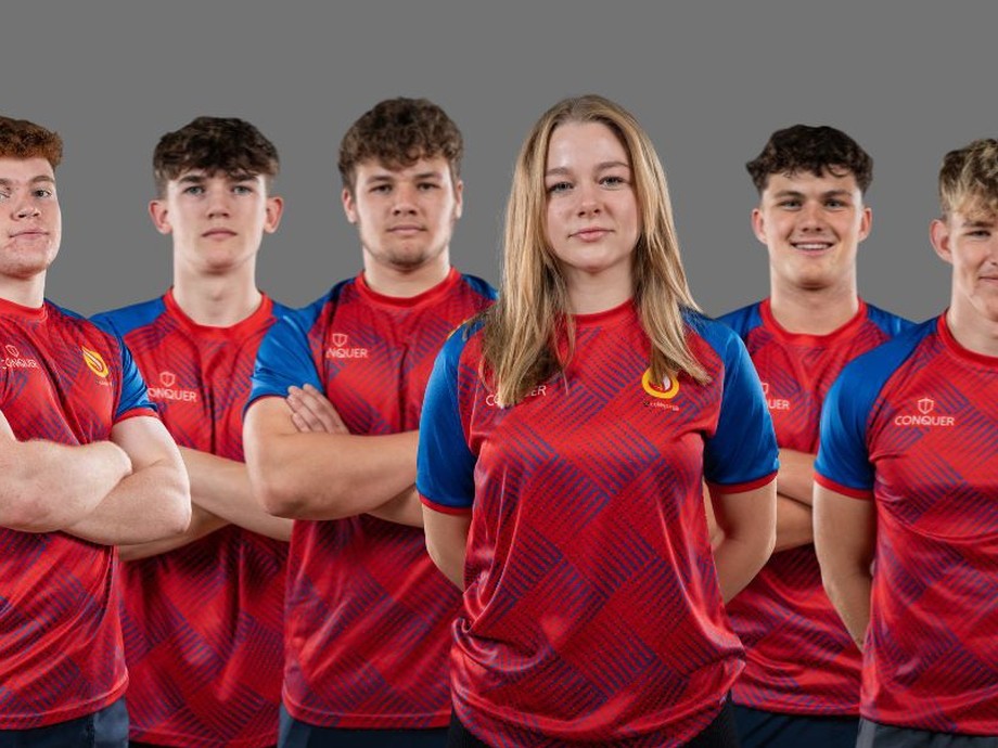 Six students lined up in their red and blue rugby kits