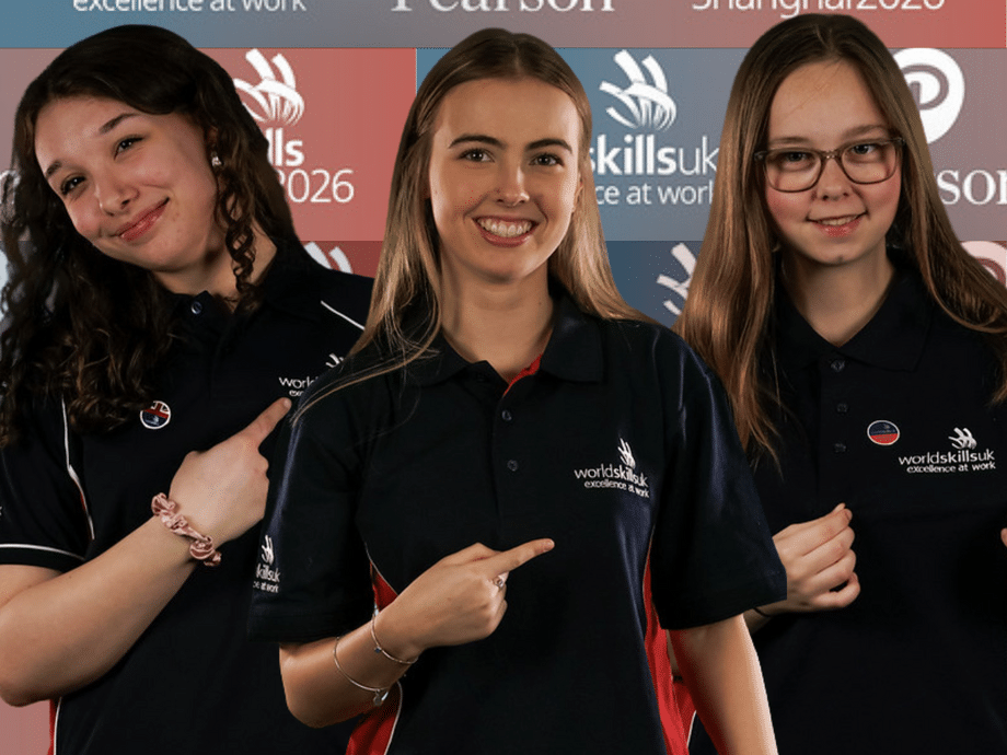 The three girls pointing to the WorldSkills logo on their tops with a branded WorldSkills and Pearson background