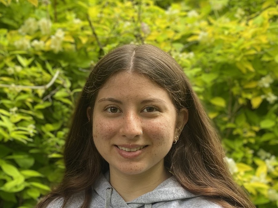 Hannah in front of some greenery wearing a Princeton hoodie
