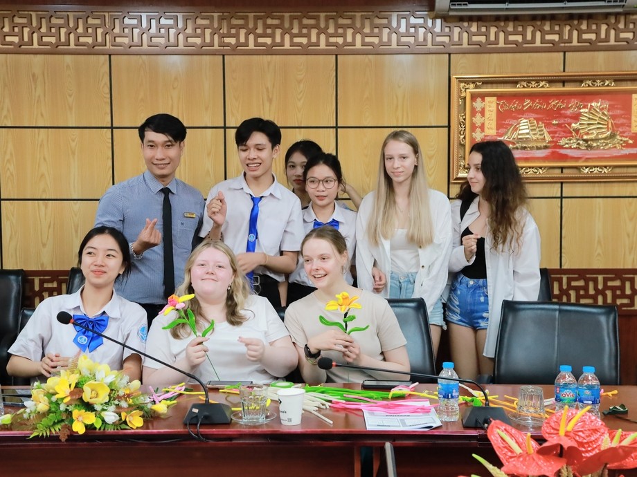 Students and staff with Vietnamese representatives behind a desk in two rows