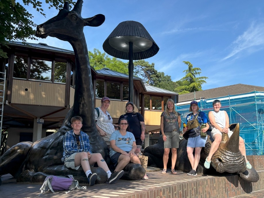 The group outside an attraction with an oversized giraffe statue