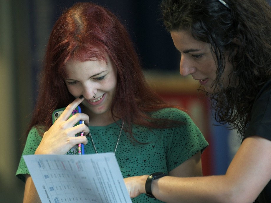 A student looking at her results happily with a lecturer guiding her through them