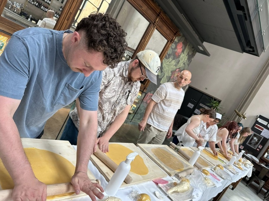 Students in a row taking part in a pasta making workshop with Dan their tutor