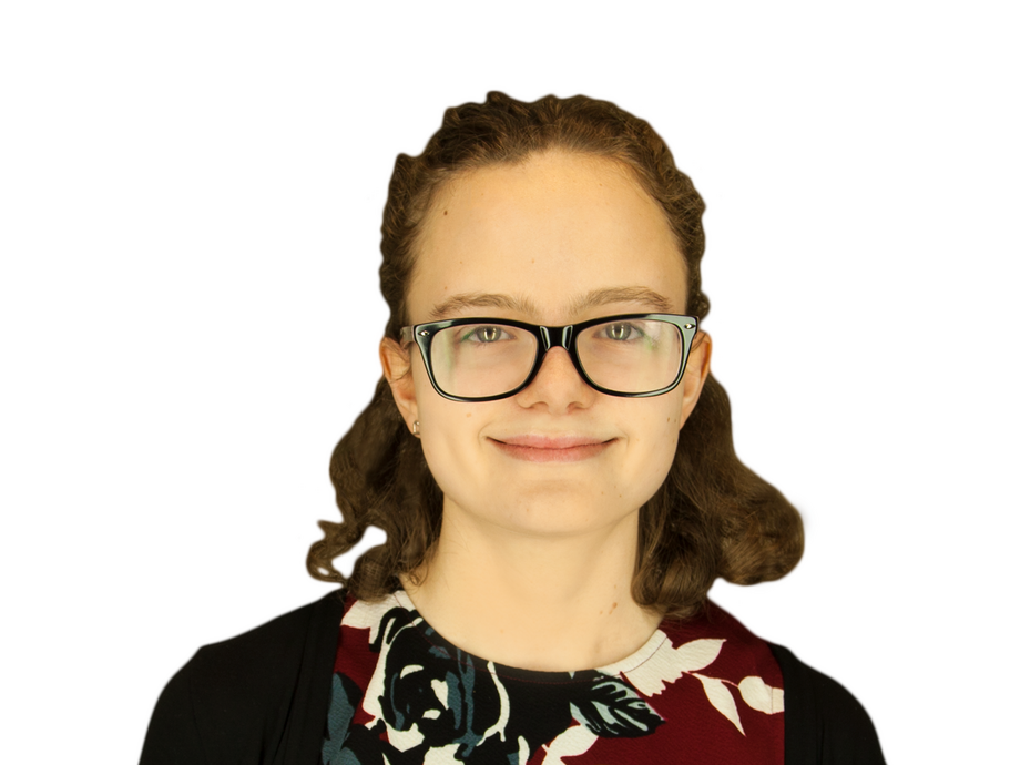 A picture of Victoria wearing a black cardigan and maroon/black/white pattered top 