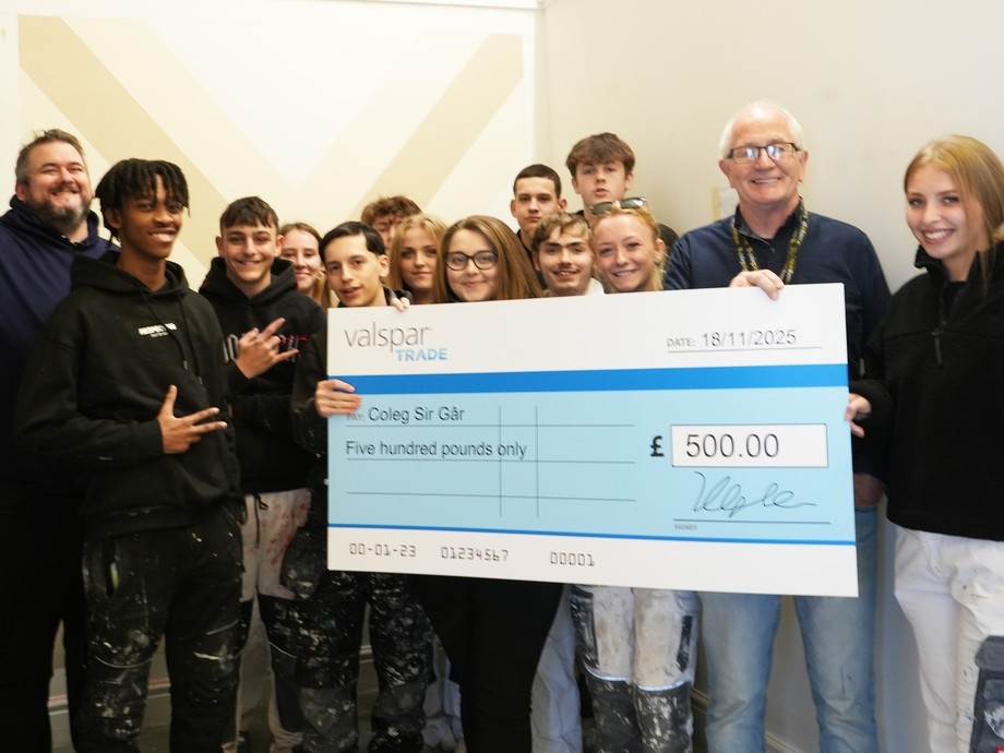 A group of students with their lecturer and reps from Valspar Trade holding an oversized cheque