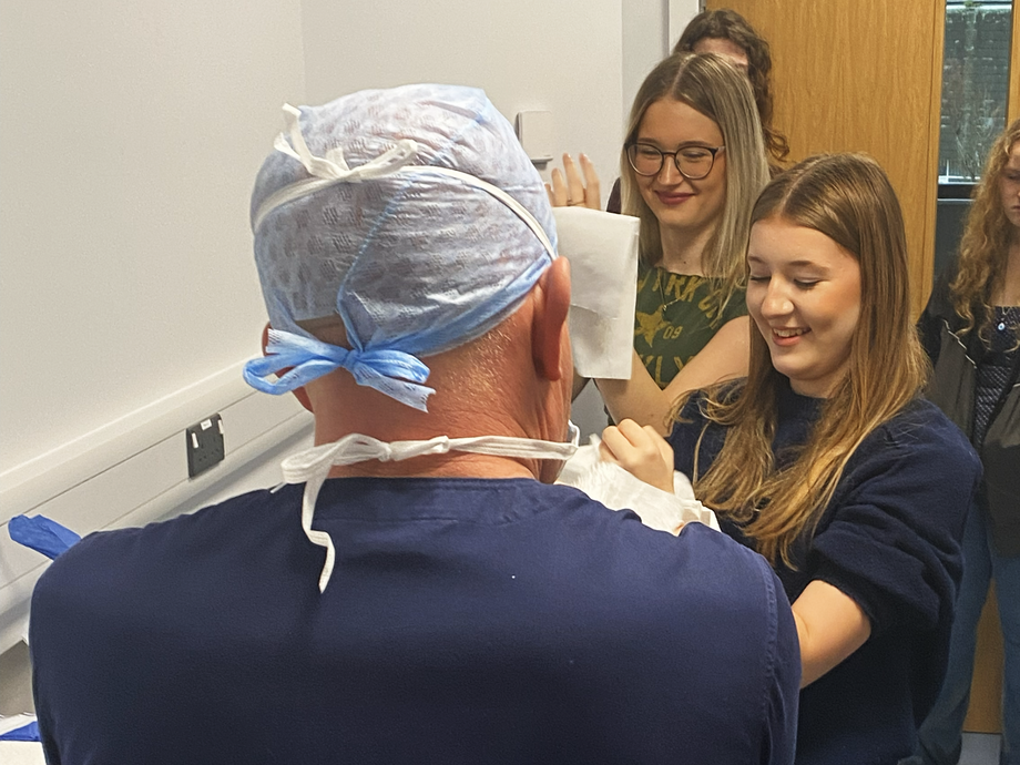 The back of the trainer helping students to scrub up