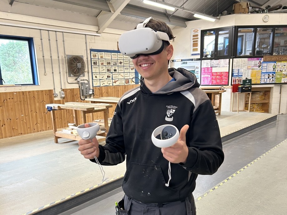 A carpentry student in work clothes wearing a VR set