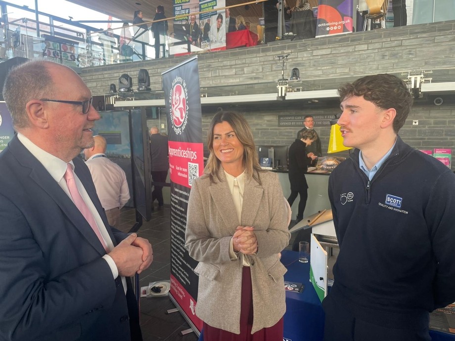 The team in the Senedd with an apprentice talking to a dignitary 
