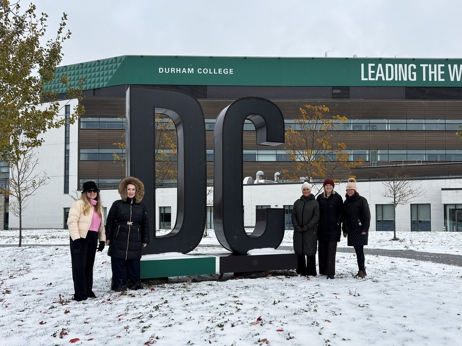 Staff outside Durham College (sign)