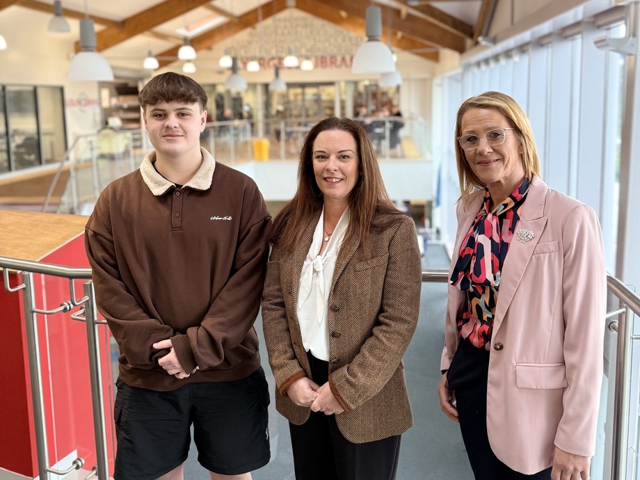 Ioan with the minister and a vice principal on the second floor with beams on the ceiling