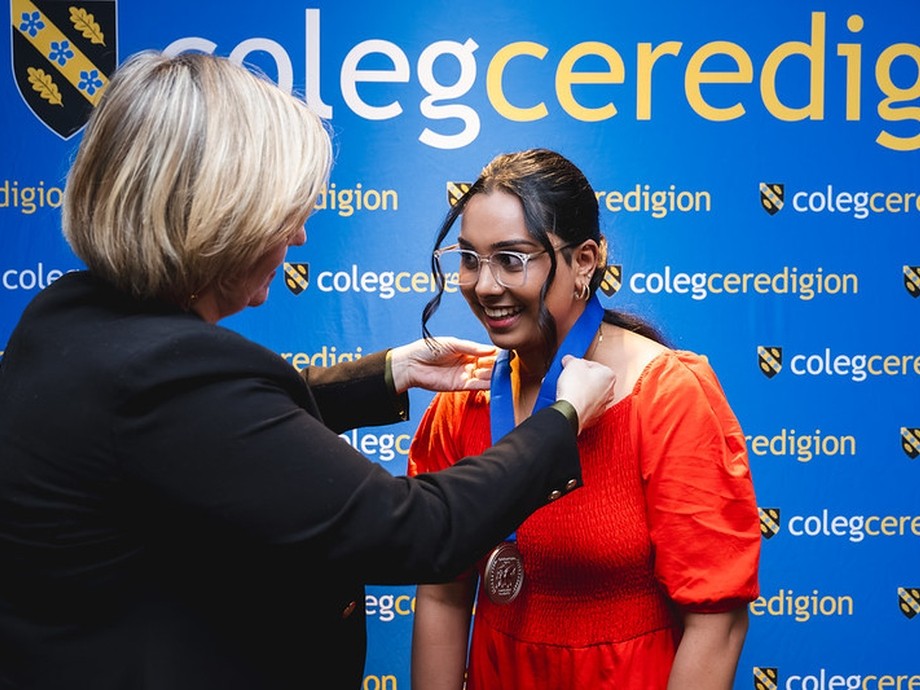 A student being given her medal by vice principal Vanessa