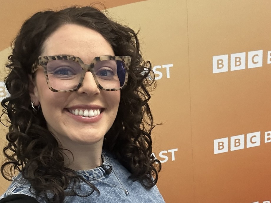 Georgia taking a selfie in front of the BBC branding 