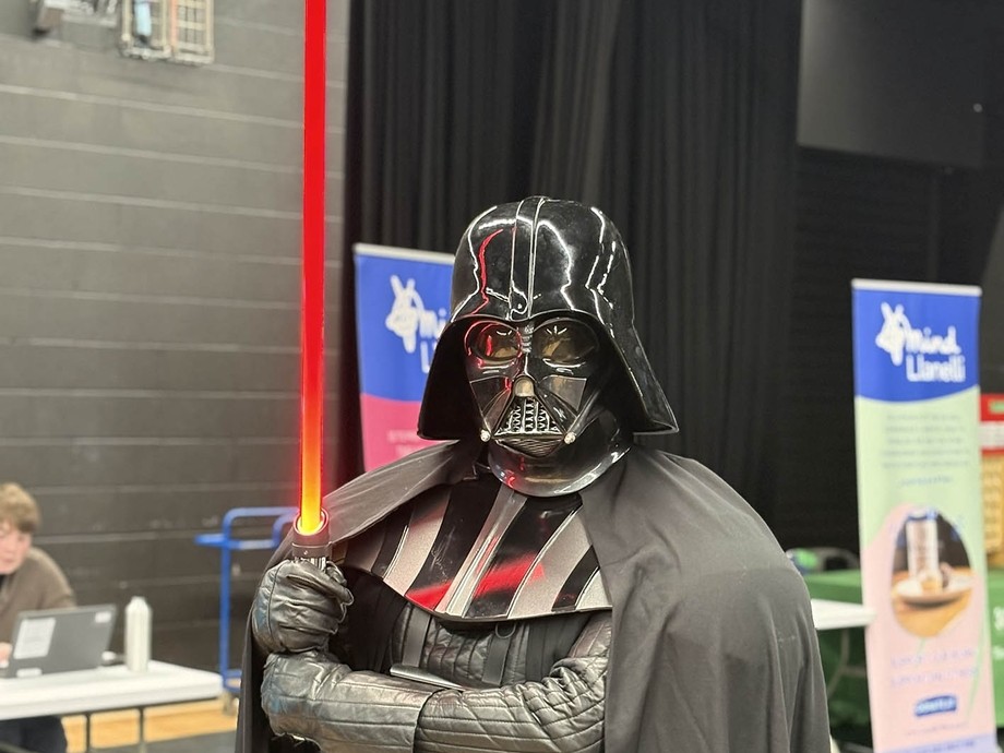 Darth Vader looking at the camera holding a light saber