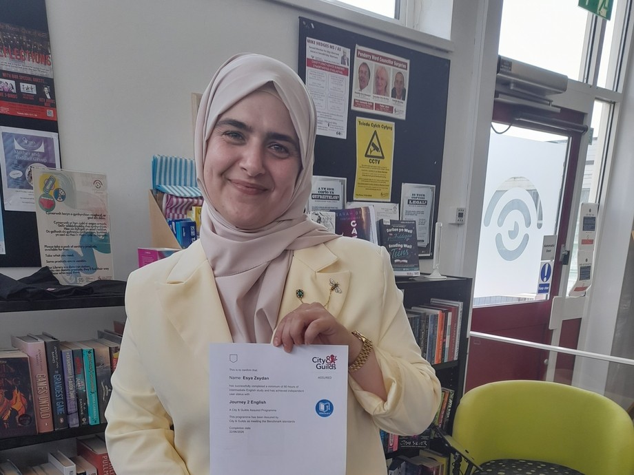 Asia standing in the library holding her certificate