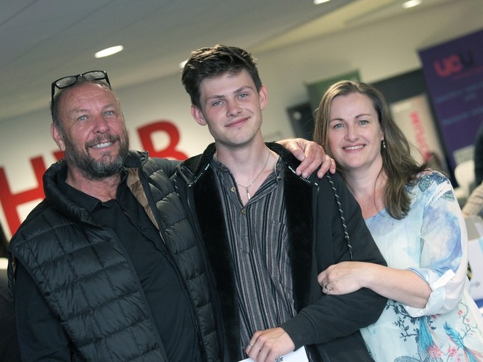 A student with her parents looking happy