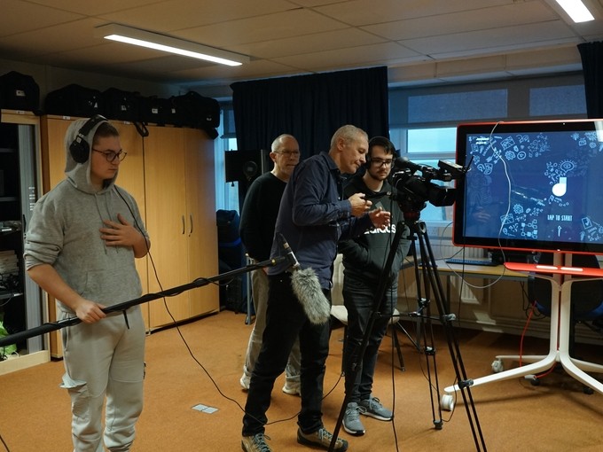 Simon and his team working with students with screens and mics