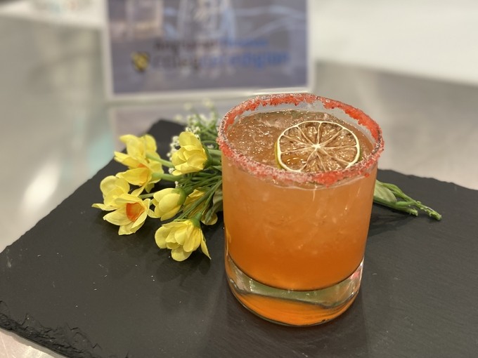 A picture of a cocktail it's orange and well presented for judging