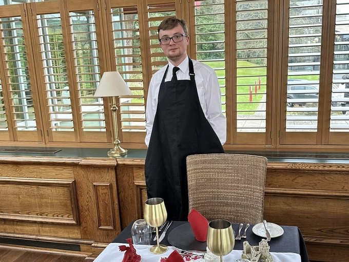 Corey standing behind his laid table at the competition
