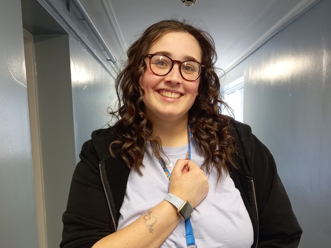 A staff member making a heart with her hands