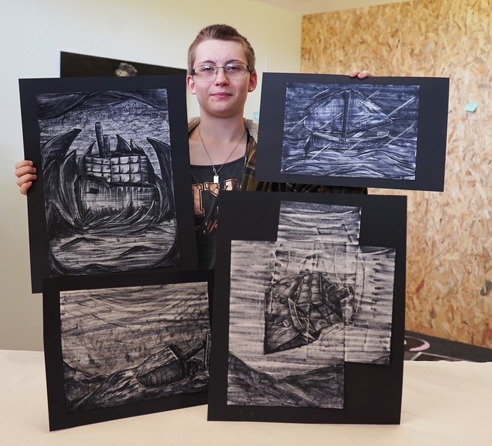 Nicole standing holding her work