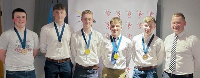 A line of male students with Rhodri all wearing their medals (5)