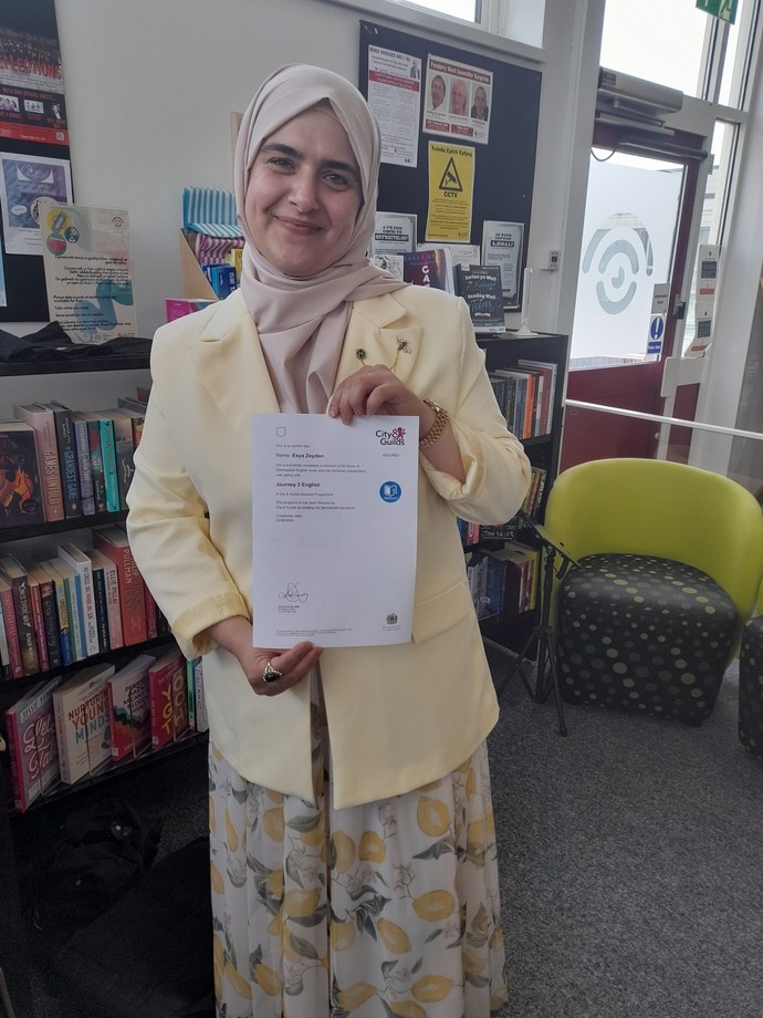 Asia standing in the library holding her certificate
