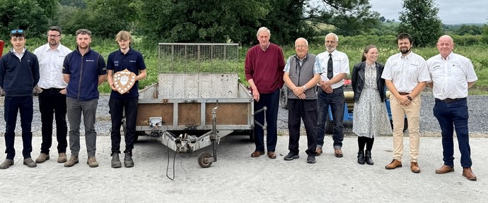 A line of students judges and staff by the winning manufactured design