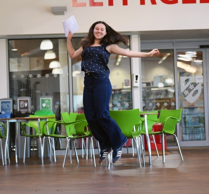 katy Hamilton jumping with her certificate for a photo