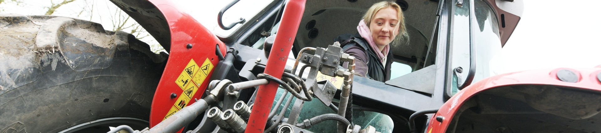 A student driving a tractor.