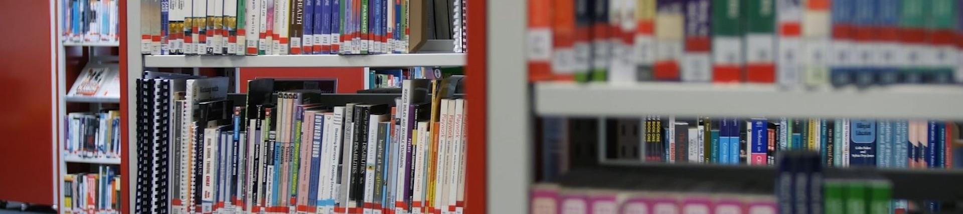 Close up on some library shelves full of books.