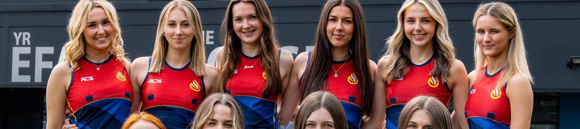 Netball team in red and blue uniform.