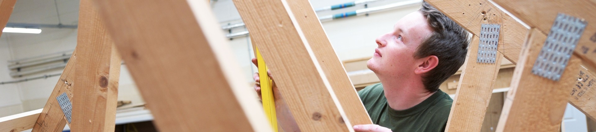 Construction student measuring a timber frame.