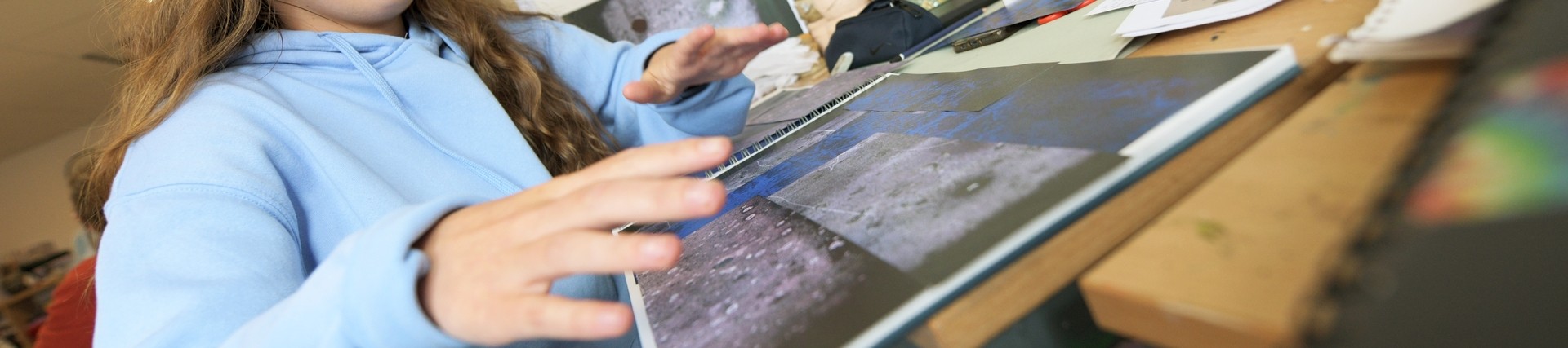 A student displays some prints. 