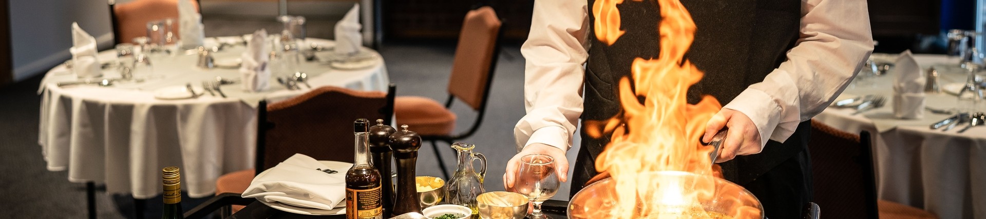 Student frying a dish on mobile hob in restaurant