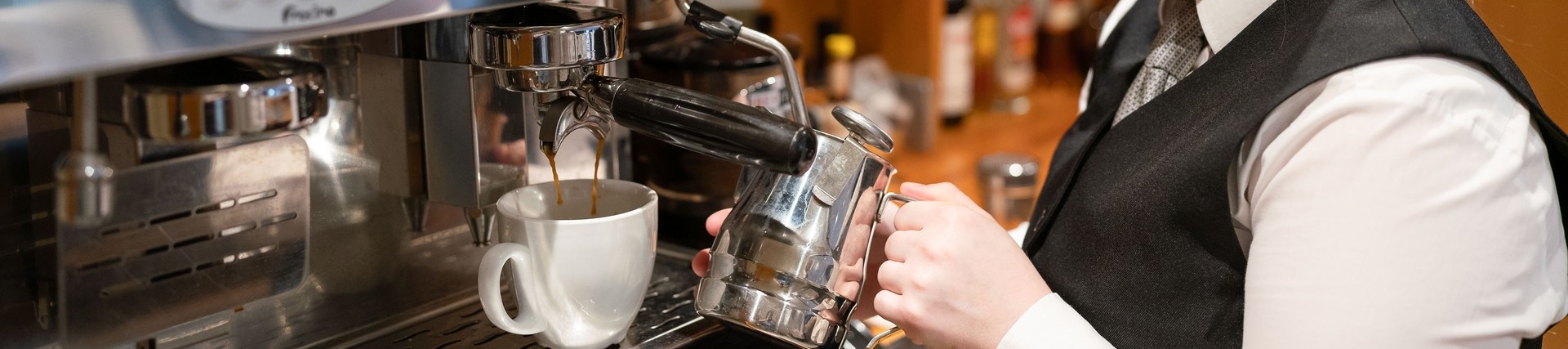 Student preparing coffee at barista station 